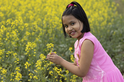 Portrait of smiling girl with yellow flowering plants