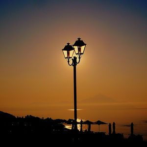 Low angle view of silhouette street light against sky at sunset