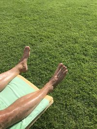 Low section of person relaxing on field