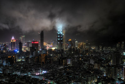 Panoramic view over taipei 101 and surrounding buildings at night during a rain storm. 