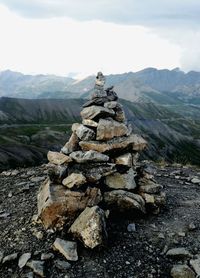 Stack of rocks on mountain against sky