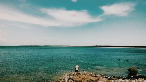 Person overlooking calm blue sea