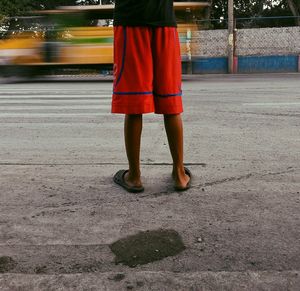 Low section of woman standing on road