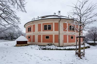 House on snow covered field against sky