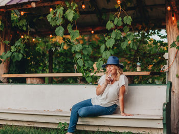 Young woman looking away while sitting on plants