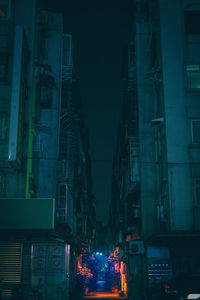 Alley amidst buildings in city at night