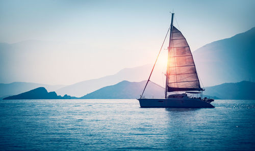 Sailboat sailing on sea against sky