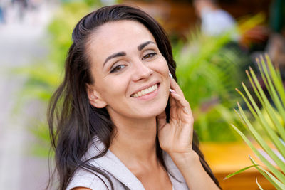 Happy successful business woman standing on city street, thinking about