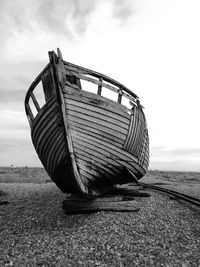 Abandoned boat on beach against sky