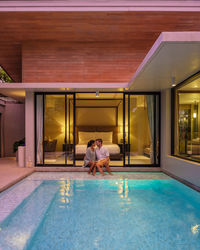 Rear view of woman sitting in swimming pool