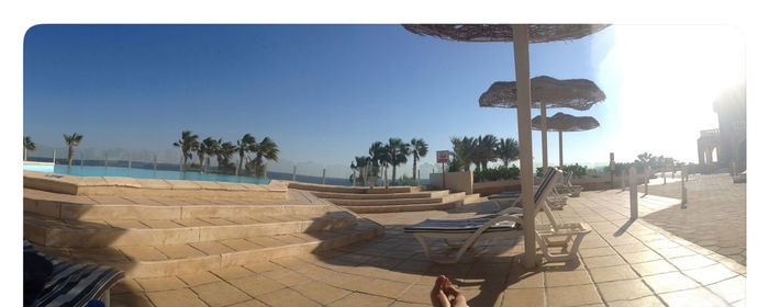 View of lounge chairs at swimming pool