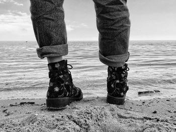 Low section of man standing on beach