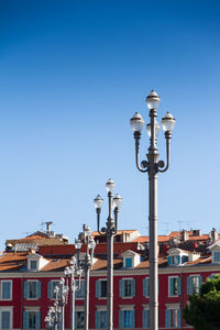 Low angle view of street light against buildings in city