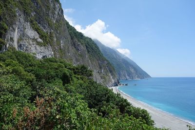 Scenic view of sea and mountains against sky