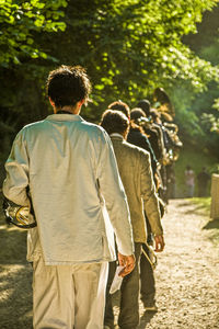 Rear view of people walking on road