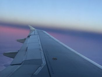 Cropped image of airplane wing against clear blue sky