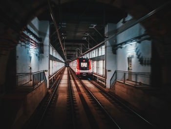 Train at railroad station platform seen through tunnel