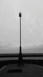 Street light on beach against sky