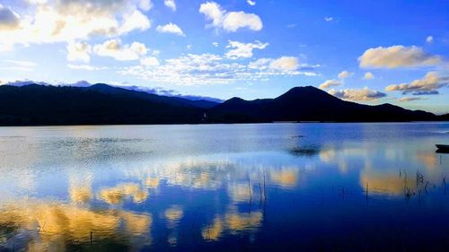 Scenic view of lake by mountains against sky