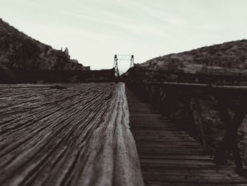 Wooden footbridge against sky