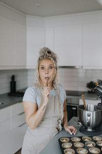 Woman in kitchen preparing cupcakes