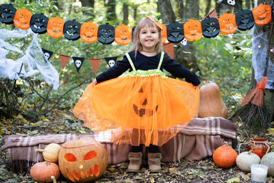 Halloween. cute little girl in pumpkin costume having fun, celebrating halloween outdoor