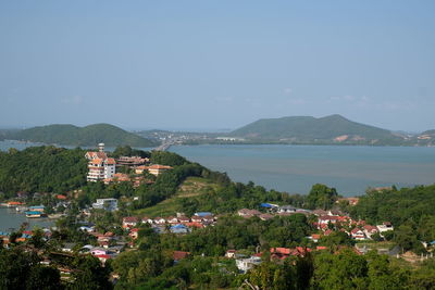 Scenic view of town by sea against sky