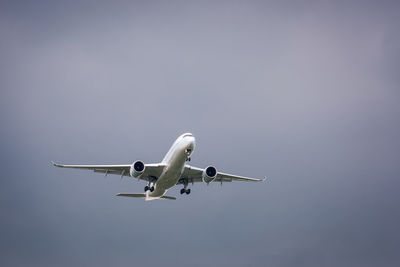 Low angle view of airplane flying against sky