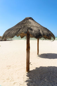 Built structure on beach against clear blue sky