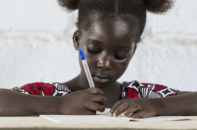 Portrait of girl holding camera on table