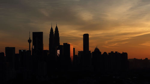 Silhouette buildings against sky during sunset