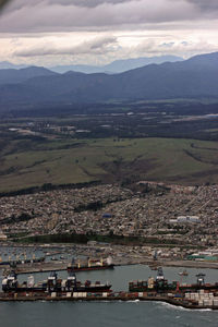 High angle view of river by mountains against sky