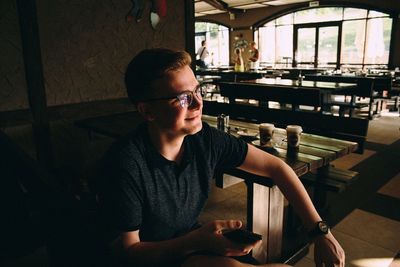 Portrait of young man sitting in restaurant