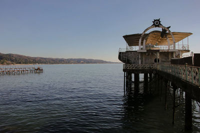 Pier over lake against clear sky