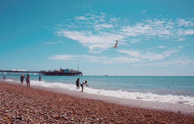 People on beach against sky