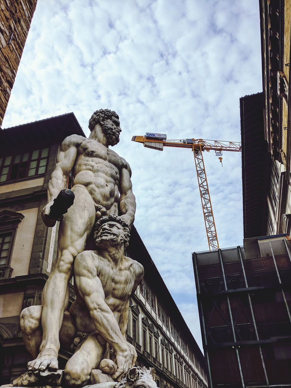 LOW ANGLE VIEW OF STATUE AGAINST BUILDINGS