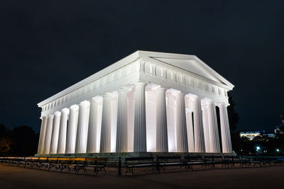 Low angle view of illuminated building against sky at night