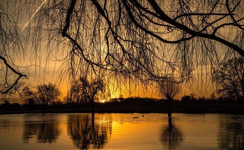 Scenic view of lake against sky at sunset