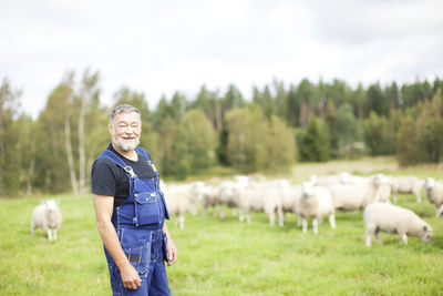 Senior farmer standing on pasture, smaland, sweden