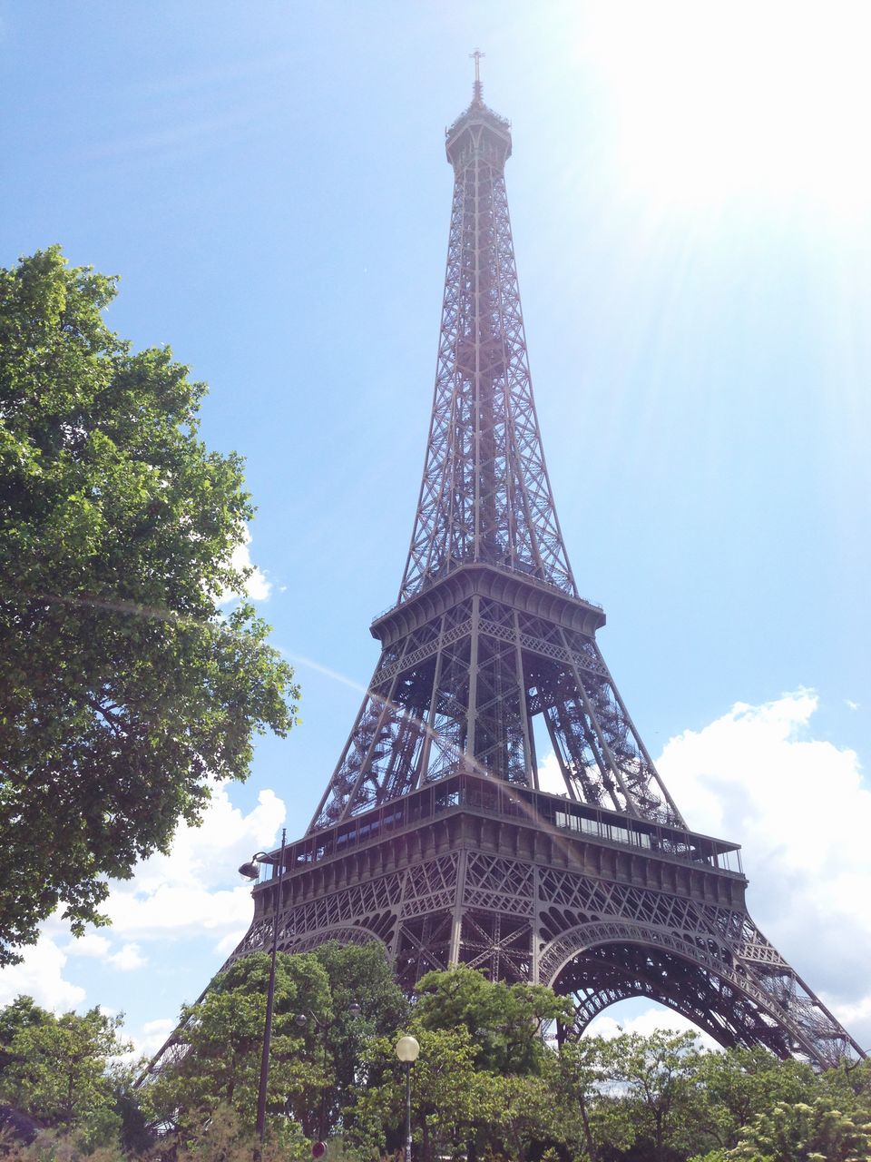 eiffel tower, famous place, international landmark, architecture, travel destinations, tourism, built structure, tower, travel, culture, tall - high, capital cities, low angle view, history, sky, tree, architectural feature, metal, city, building exterior