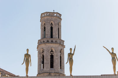 Low angle view of statue of historic building against sky