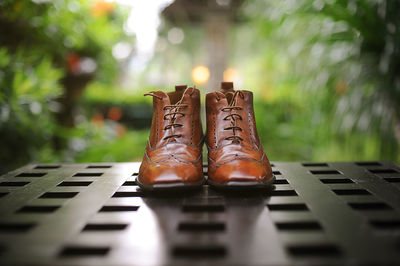 Close-up of brown leather boots on metal grate