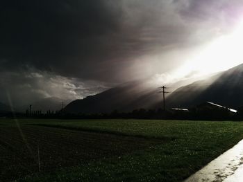 Scenic view of grassy field against cloudy sky