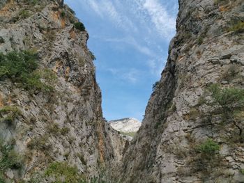 Low angle view of rocky mountains against sky