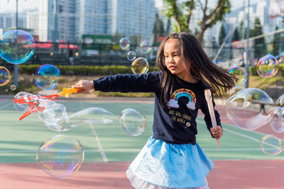 Full length of woman with bubbles in background