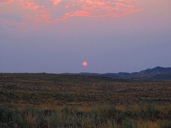 Scenic view of field against sky at sunset