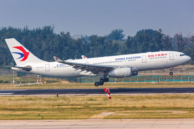 Side view of airplane on airport runway against sky