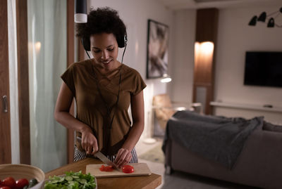 Mixed race woman cooking and listening to music