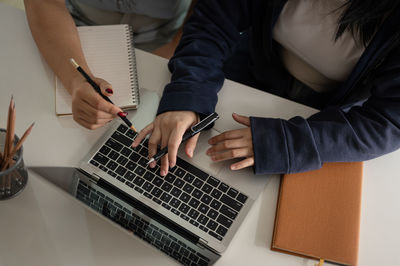 Midsection of man using laptop on table