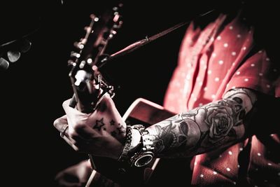 Midsection of man playing guitar